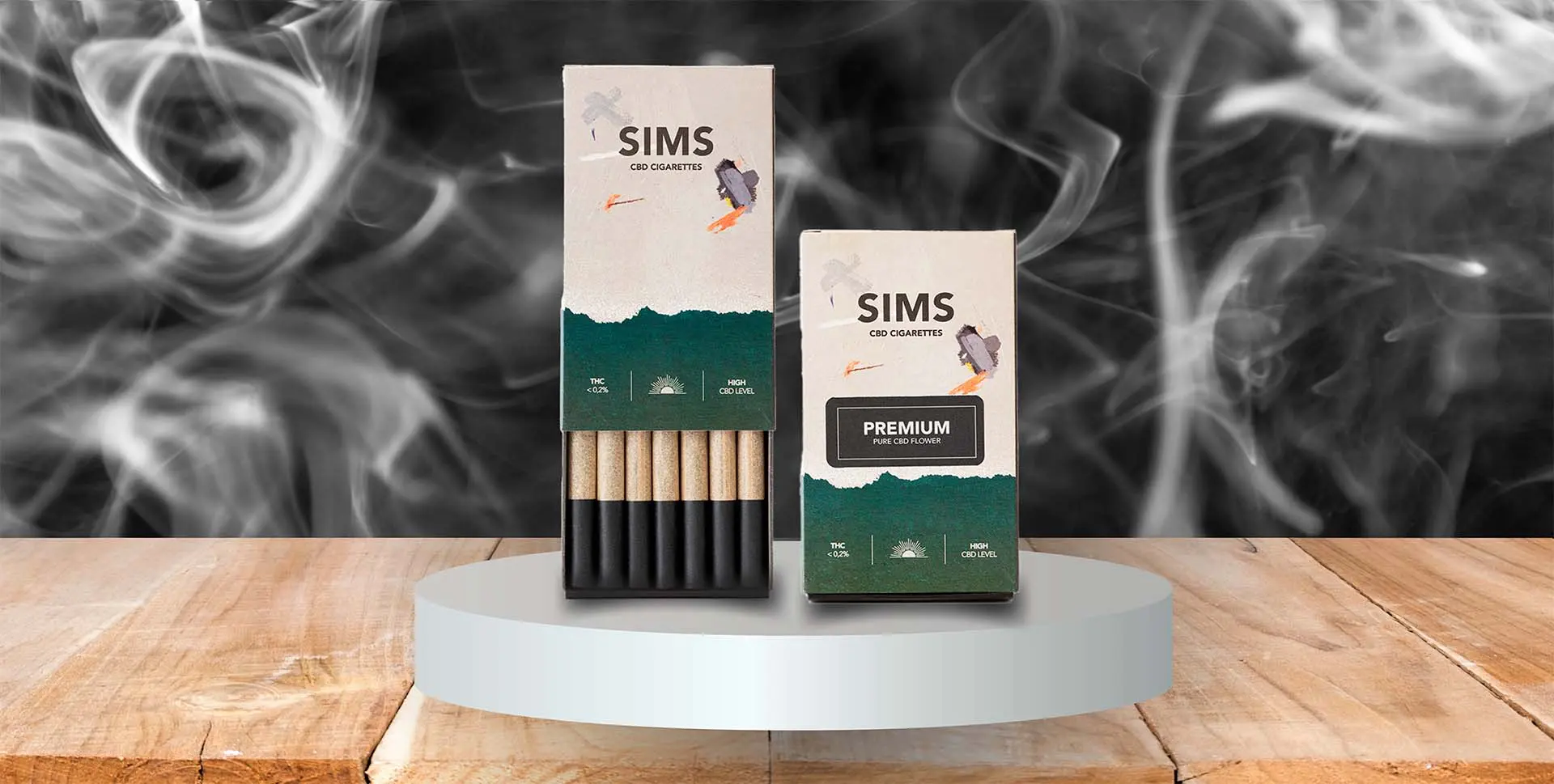 Dos cajas de cigarrillos de CBD SIMS una normal y otra premium envueltas de humo